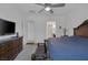 This main bedroom features a ceiling fan, carpeted floor, TV on dresser, bench at the end of bed, and an ensuite at 10181 Mount Harlow Ct, Las Vegas, NV 89141