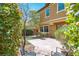 Private backyard with a patio area, artificial grass, and lush green landscaping at 10404 Mystic Pine Rd, Las Vegas, NV 89135