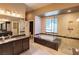 Luxurious bathroom featuring dual sinks, large soaking tub, and expansive glass shower at 10404 Mystic Pine Rd, Las Vegas, NV 89135