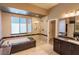 Well-lit bathroom with dual sinks, separate shower and tub, and large vanity mirror at 10404 Mystic Pine Rd, Las Vegas, NV 89135