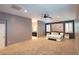 Bright main bedroom with plush carpeting, neutral walls, shutters, and attached bathroom at 10404 Mystic Pine Rd, Las Vegas, NV 89135