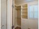 Bright walk-in closet with white shelving, storage and a view of the window on the right at 10404 Mystic Pine Rd, Las Vegas, NV 89135