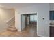 Inviting entryway with tile flooring, staircase, and open doorway leading to a bright, window-filled room with modern shutters at 10404 Mystic Pine Rd, Las Vegas, NV 89135
