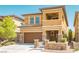 Charming two-story home with a brown garage door, accented with stone pillars and a well-kept lawn at 10404 Mystic Pine Rd, Las Vegas, NV 89135