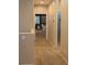 Neutral colored hallway features carpet and a view into a room with a bed, nightstand, art, and plantation shutters at 10404 Mystic Pine Rd, Las Vegas, NV 89135