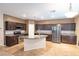 Modern kitchen features an island, stainless steel appliances, and dark wood cabinets, offering ample storage at 10404 Mystic Pine Rd, Las Vegas, NV 89135