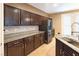 Well-equipped kitchen with stainless steel appliances, granite countertops, and dark wood cabinets, creating a modern design at 10404 Mystic Pine Rd, Las Vegas, NV 89135