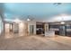 Open-concept living room showcasing tile floors and carpet, flowing seamlessly into the kitchen area at 10404 Mystic Pine Rd, Las Vegas, NV 89135