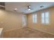 Bright loft space with a ceiling fan, recessed lighting, neutral colored walls, and a sliding glass door with white shutters at 10404 Mystic Pine Rd, Las Vegas, NV 89135