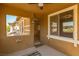 Covered patio with neutral colors, an entrance door, and view of backyard at 10404 Mystic Pine Rd, Las Vegas, NV 89135