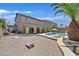 Beautifully landscaped backyard with custom pool, seating area, and mature palm trees at 10673 Bonchester Hill St, Las Vegas, NV 89141