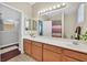 A bathroom with double vanity, tile flooring, a large mirror and plenty of lighting at 10673 Bonchester Hill St, Las Vegas, NV 89141