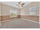 A secondary bedroom with neutral carpeting and paint, ceiling fan, and natural light at 10673 Bonchester Hill St, Las Vegas, NV 89141