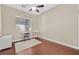 A secondary bedroom features wood floors, neutral paint and plenty of natural light at 10673 Bonchester Hill St, Las Vegas, NV 89141