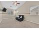 This bonus room includes a ceiling fan, TV, ample natural light, neutral paint scheme, and plush carpeting at 10673 Bonchester Hill St, Las Vegas, NV 89141