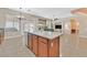 Open kitchen featuring an island with sink and dishwasher, wood cabinets and a view of the living room at 10673 Bonchester Hill St, Las Vegas, NV 89141