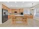 Traditional kitchen with stainless steel appliances, wood cabinets, tile backsplash, and breakfast bar with seating at 10673 Bonchester Hill St, Las Vegas, NV 89141