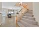 Carpeted stairs lead to an open living room with a fireplace, fan and lots of natural light at 10673 Bonchester Hill St, Las Vegas, NV 89141