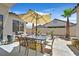 Charming backyard patio with stone floor, table, umbrella, and desert landscaping at 10701 Morning Harbor Ave, Las Vegas, NV 89129