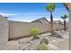 Backyard features desert landscaping, rock features, and a high block wall for privacy at 10701 Morning Harbor Ave, Las Vegas, NV 89129