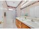 Bathroom featuring a double vanity, mirror, and shower-tub combination at 10701 Morning Harbor Ave, Las Vegas, NV 89129