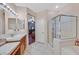 Bright bathroom features a glass enclosed shower, vanity and tile floors at 10701 Morning Harbor Ave, Las Vegas, NV 89129