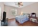 Cozy bedroom with wood floors, ceiling fan, and furniture at 10701 Morning Harbor Ave, Las Vegas, NV 89129
