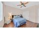 Bedroom with light blue bedspread, ceiling fan, and wood floors at 10701 Morning Harbor Ave, Las Vegas, NV 89129