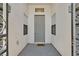 The home has a gray front door with sidelights and a decorative welcome mat at 10701 Morning Harbor Ave, Las Vegas, NV 89129