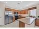 Well-lit kitchen showcases stainless steel appliances, warm wooden cabinets, and ample counter space at 10701 Morning Harbor Ave, Las Vegas, NV 89129