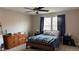 Bedroom with a ceiling fan, a large bed and curtains hanging over the windows at 10804 Mason Hill Ave, Las Vegas, NV 89166