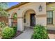 Inviting front entrance with arched porch, mature shrubs, and stylish outdoor lighting at 10804 Mason Hill Ave, Las Vegas, NV 89166