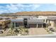 Aerial view of modern home with a paver driveway, two-car garage, and desert landscaping in a new development at 10919 Vista Altura Ave, Las Vegas, NV 89135