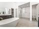 Modern bathroom featuring a soaking tub, sleek vanity, and a spacious marble-tiled shower with glass enclosure at 10919 Vista Altura Ave, Las Vegas, NV 89135