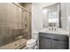 A clean and bright bathroom with a glass shower and dark cabinets at 10919 Vista Altura Ave, Las Vegas, NV 89135