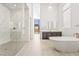 Bright open bathroom featuring a soaking tub, double vanity, and a spacious marble-tiled shower with glass enclosure at 10919 Vista Altura Ave, Las Vegas, NV 89135