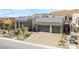 Aerial view of a modern home with a paver driveway, desert landscaping, and a two-car garage in a desert community at 10919 Vista Altura Ave, Las Vegas, NV 89135