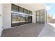The covered patio features a brick-paved surface, white stucco walls with black-framed windows, and a modern chandelier at 10919 Vista Altura Ave, Las Vegas, NV 89135