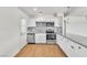 Well-lit kitchen boasting white cabinets, granite countertops, stainless appliances, and wood-look flooring at 1121 W Monroe Ave, Las Vegas, NV 89106