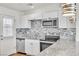A modern kitchen features stainless steel appliances, granite countertops, mosaic backsplash, and white cabinets at 1121 W Monroe Ave, Las Vegas, NV 89106
