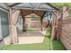 Backyard with covered patio, artificial grass, block wall and small tree at 1135 Paradise Mountain Trl, Henderson, NV 89002