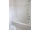 Bathroom features a bathtub with white tiling, shower head, and built-in shelves at 1135 Paradise Mountain Trl, Henderson, NV 89002