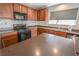 Well-lit kitchen featuring stainless steel appliances, light tile backsplash and dark countertops at 1135 Paradise Mountain Trl, Henderson, NV 89002