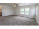 Large primary bedroom with carpet, ceiling fan, and natural light from two windows at 1135 Paradise Mountain Trl, Henderson, NV 89002