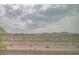 Desert landscape view with mountains, dry vegetation and cloudy sky at 1135 Paradise Mountain Trl, Henderson, NV 89002