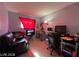 Small living room with a dark leather sofa, a television, and a work desk area at 1152 Miller Ave, Las Vegas, NV 89106
