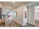Bright hallway with wood floors, decorative mirror, and access to multiple rooms throughout the home at 1324 Eva Creek Dr # 29, North Las Vegas, NV 89084