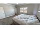 Cozy bedroom with a large window, plush carpet, and a comfortable-looking bed with white comforter at 210 Magnolia Blvd, Pahrump, NV 89048