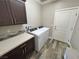 Convenient laundry room with a washer, dryer, and dark wood cabinets at 210 Magnolia Blvd, Pahrump, NV 89048