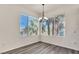 Bright dining area featuring wood-look flooring, modern lighting, and views of lush greenery at 23 E Agate Ave # 308, Las Vegas, NV 89123